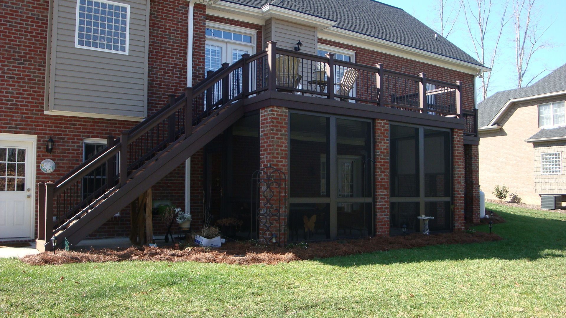 A house with a screened in porch and stairs leading up to it.