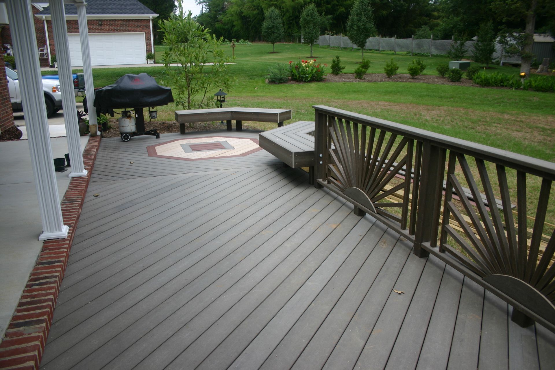 A wooden deck with a bench and a grill on it