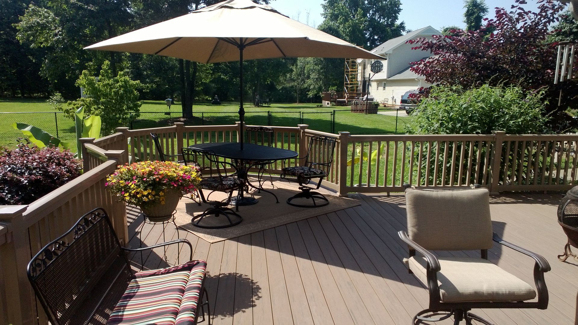 A deck with a table and chairs under an umbrella