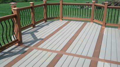 A deck with a wooden railing and a gray and brown deck.