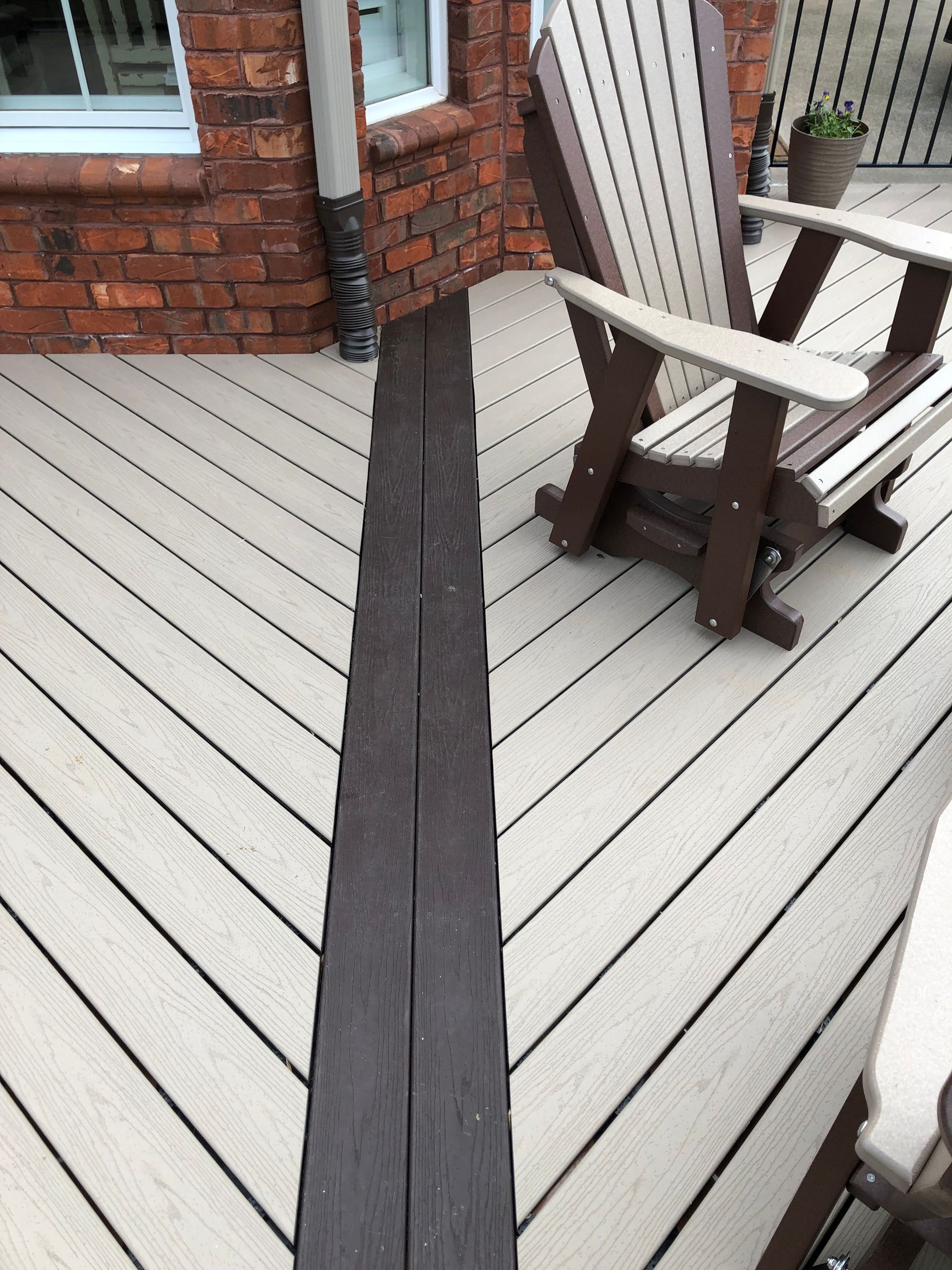 A wooden deck with a rocking chair on it