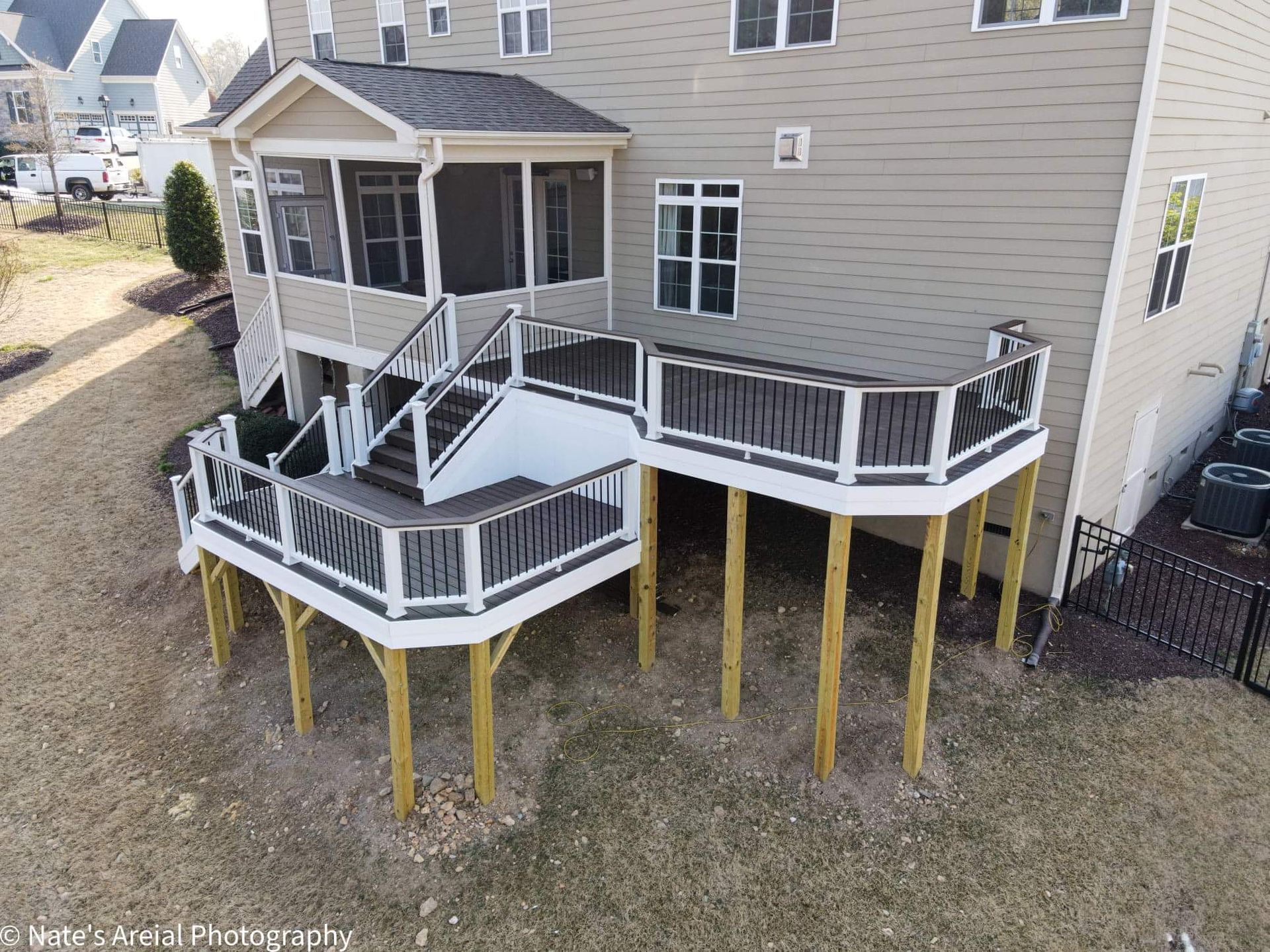 An aerial view of a house with a large deck and stairs.