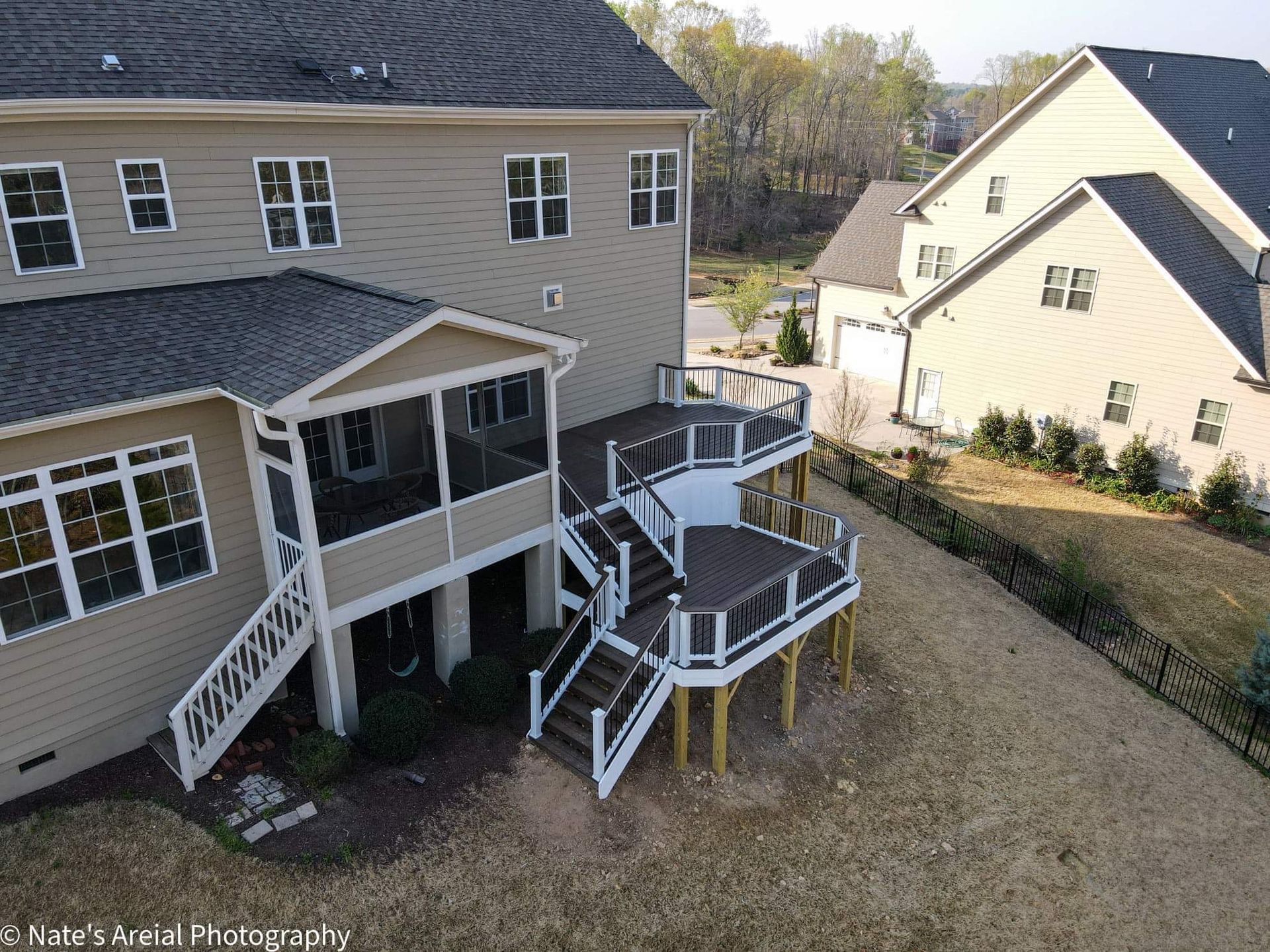 An aerial view of a house with a large deck and stairs.