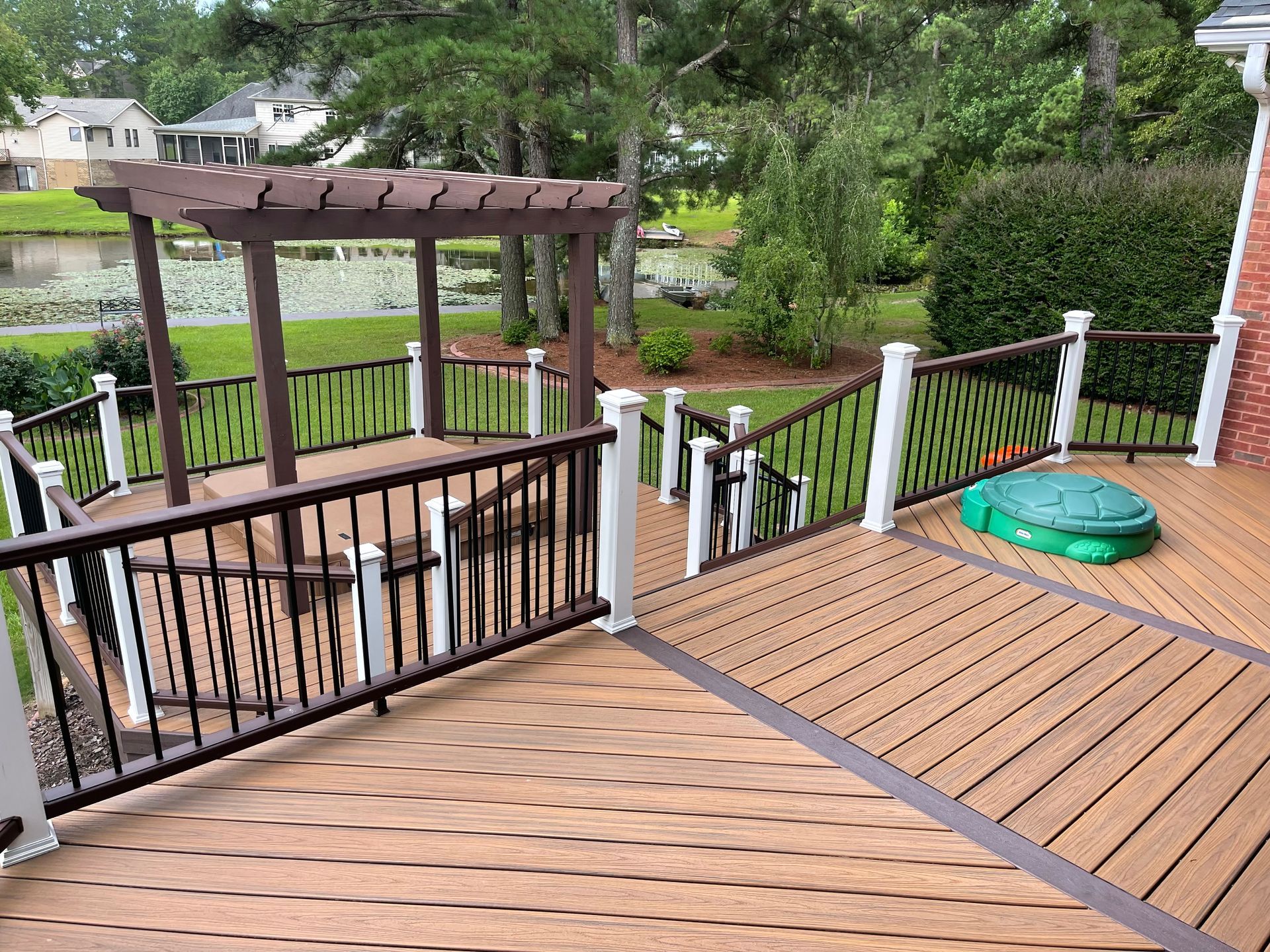 A wooden deck with a pergola and stairs leading up to it.