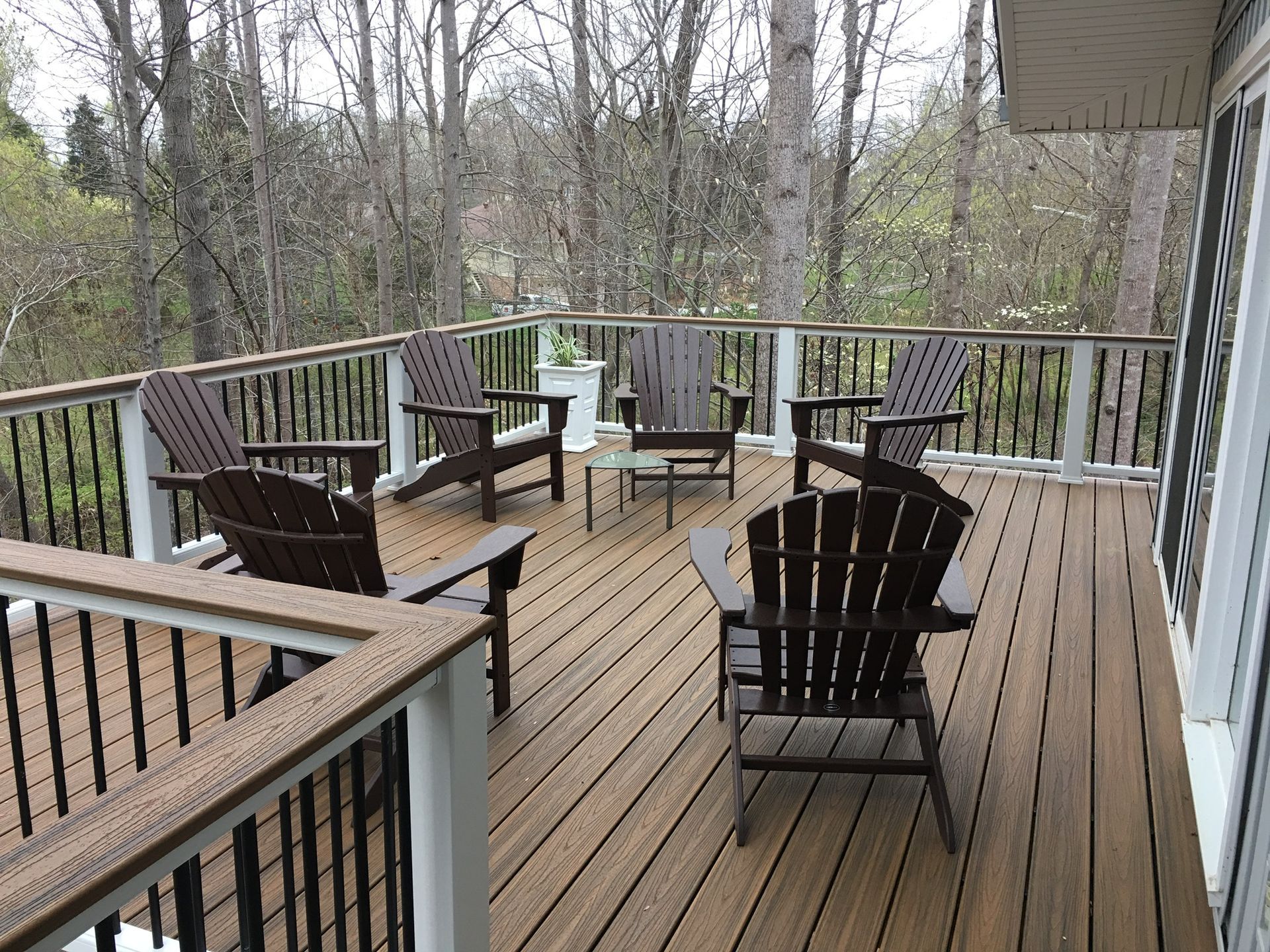 A wooden deck with chairs and a table on it.