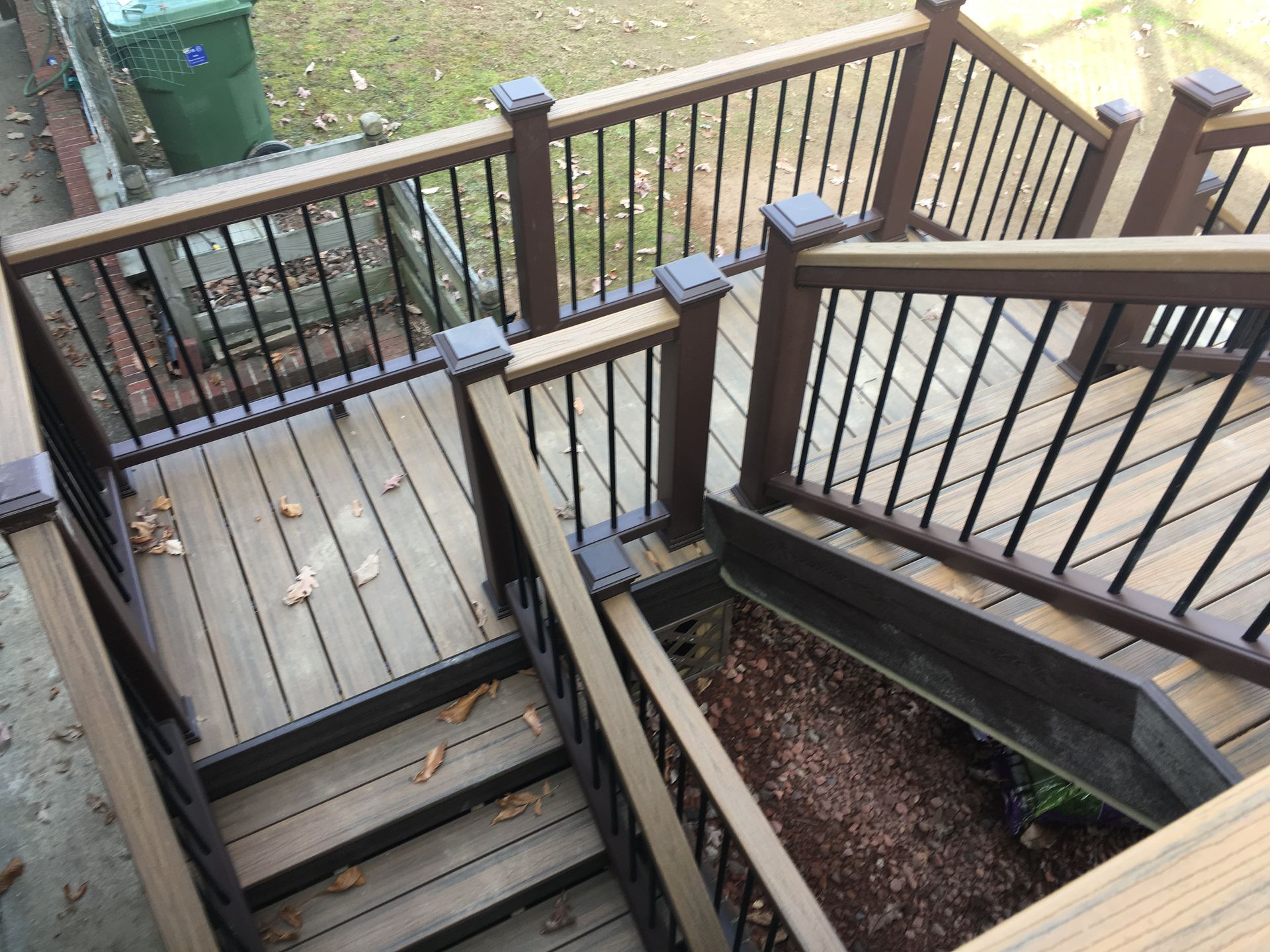 A wooden deck with stairs and a metal railing