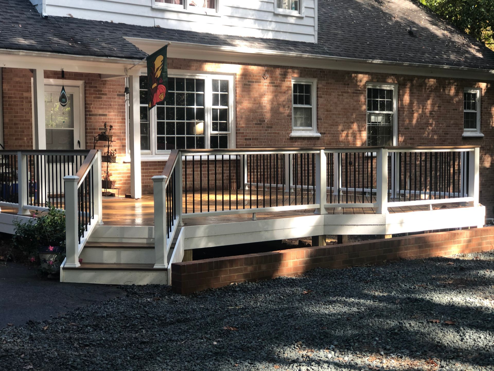 A brick house with a large deck and stairs