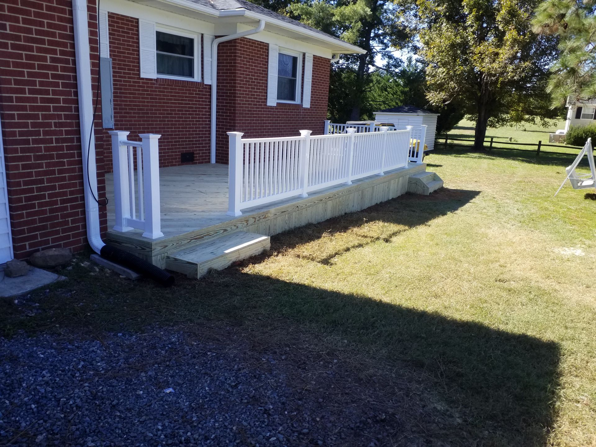 A brick house with a porch with a white railing