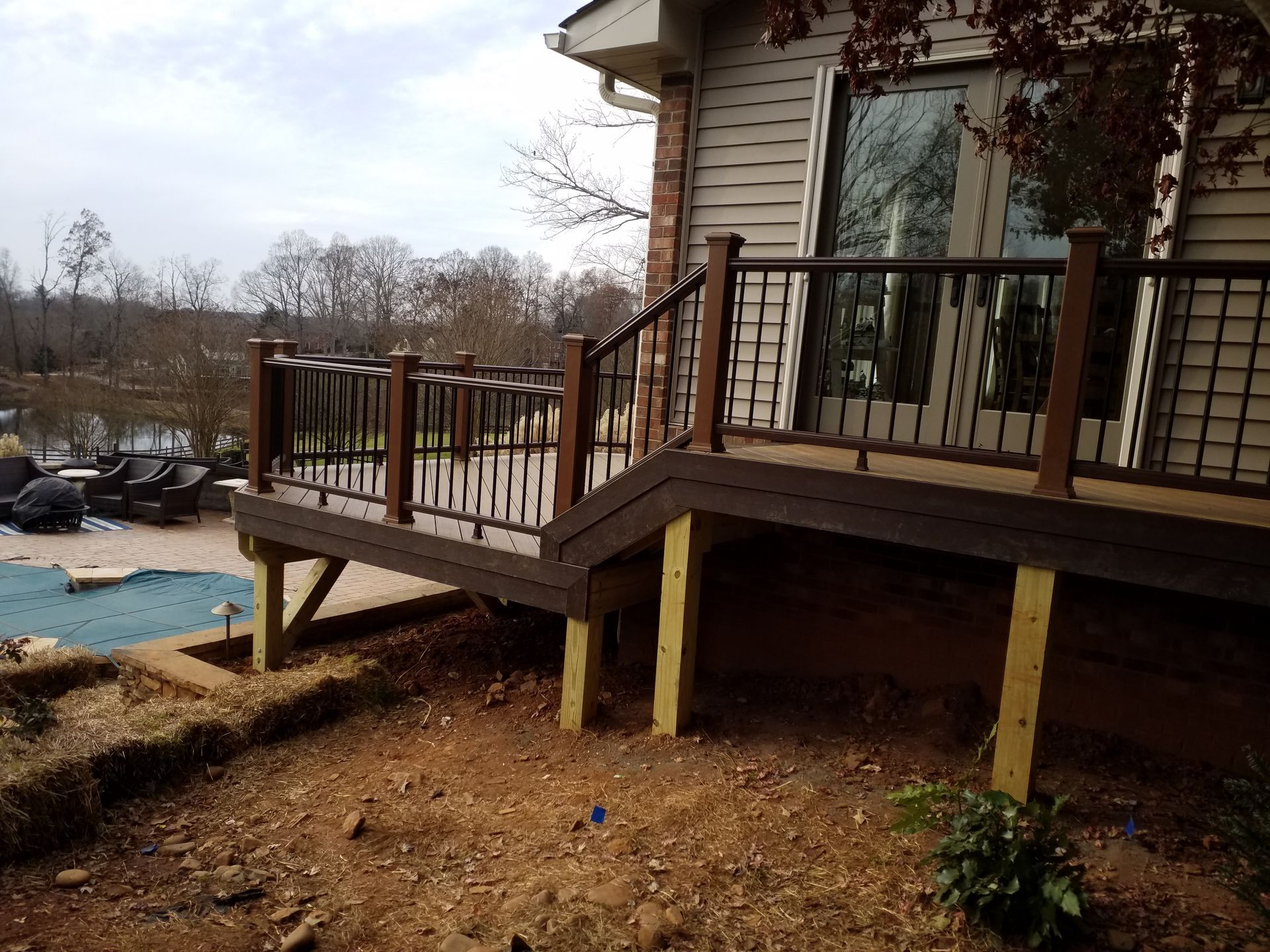 A deck with stairs leading up to it is next to a house.