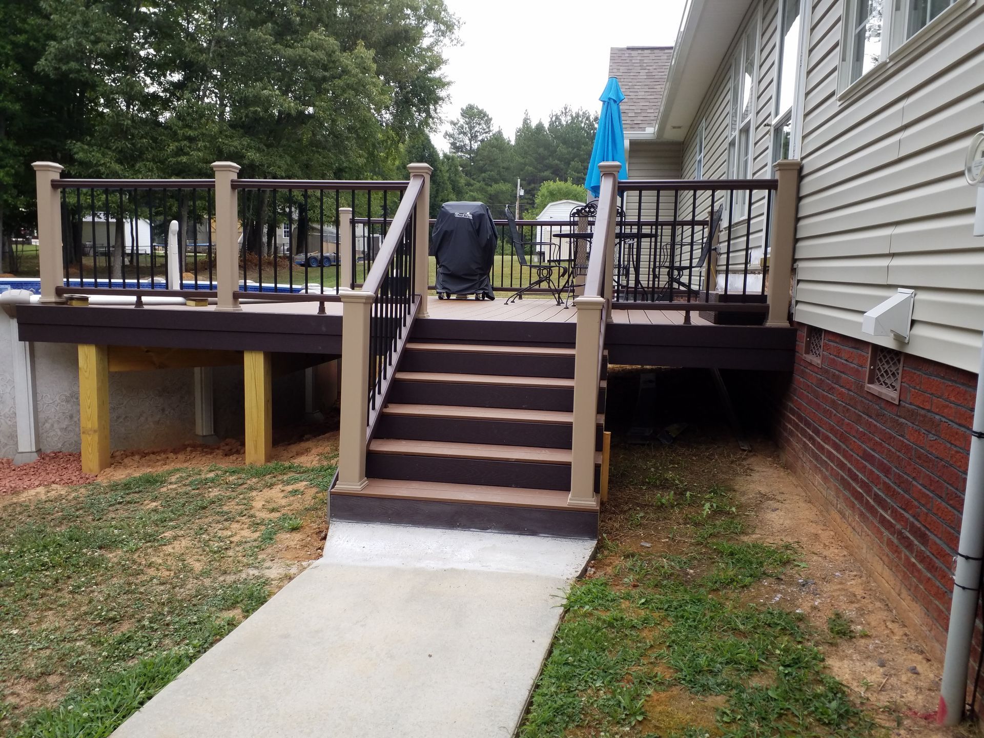 A deck with stairs leading up to it next to a house