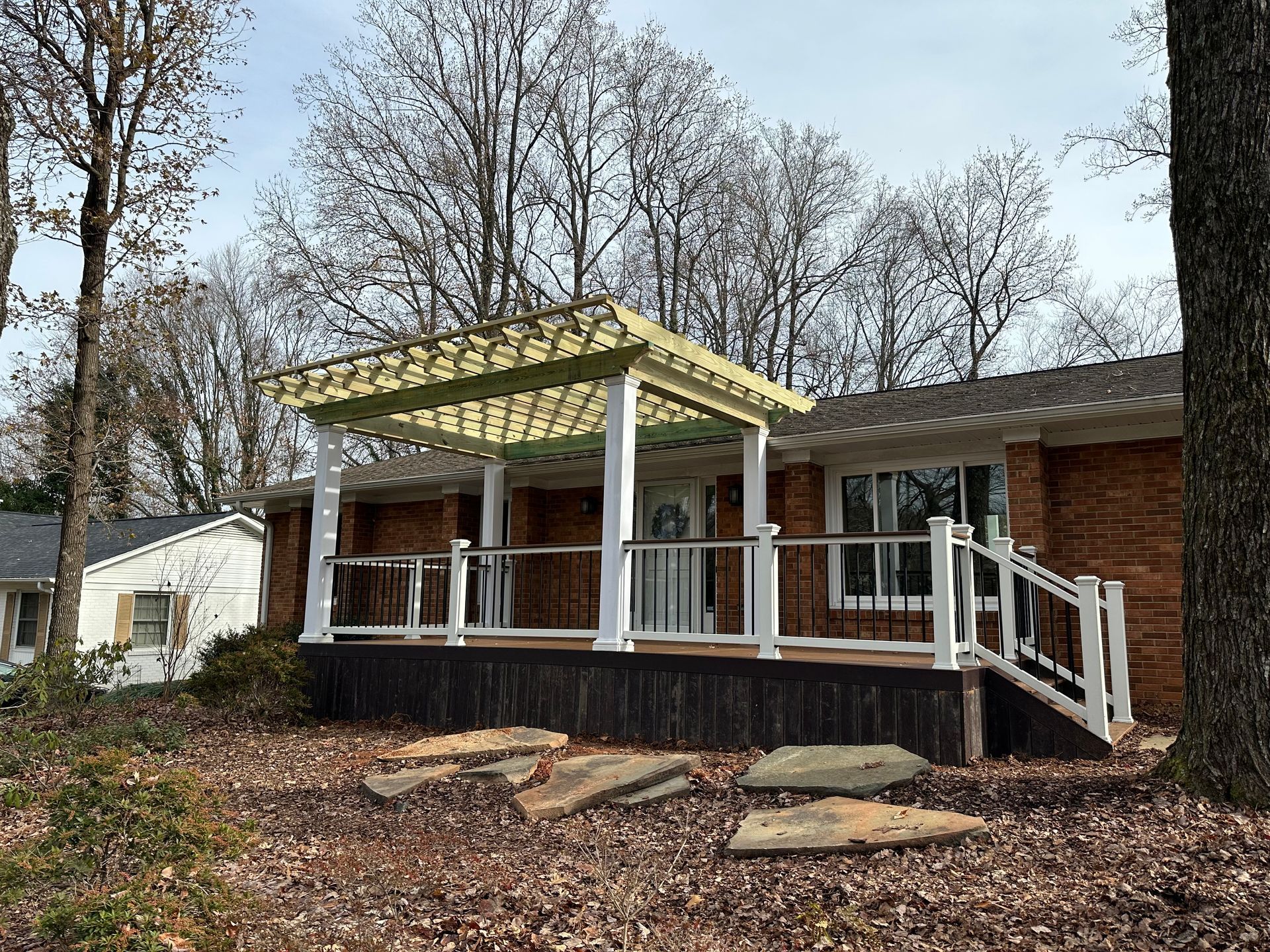 A house with a porch and a pergola on top of it.