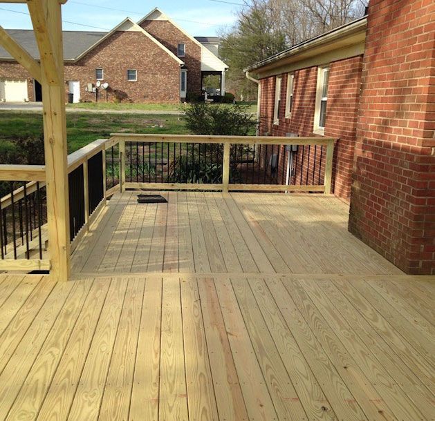 A house with a wooden deck in front of it.