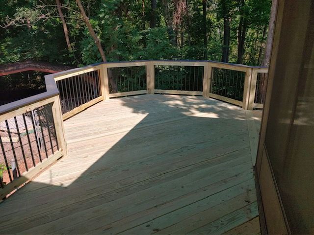 A wooden deck with a black railing.