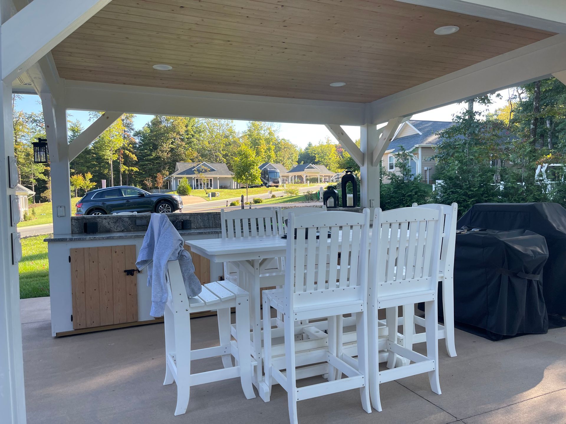 A gazebo with a table and chairs underneath it.