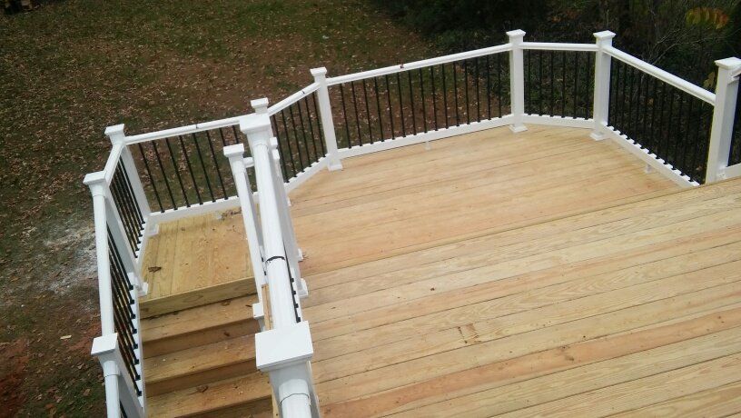 A wooden deck with stairs and a white railing.