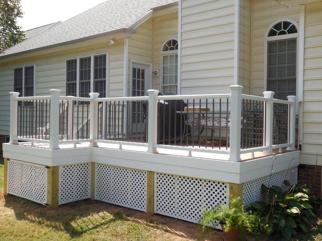 A white house with a white deck and a black railing
