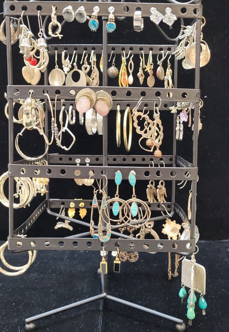 Earring display stand with many hanging earrings in various styles and colors.