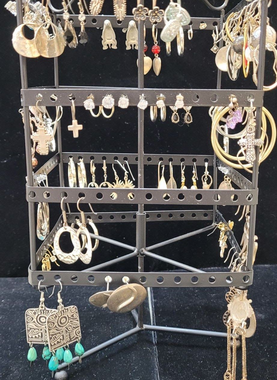 Earring display rack with numerous earrings in various styles and colors.