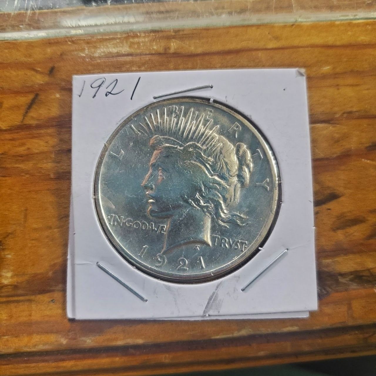 Silver Peace dollar coin from 1921 in a protective holder.