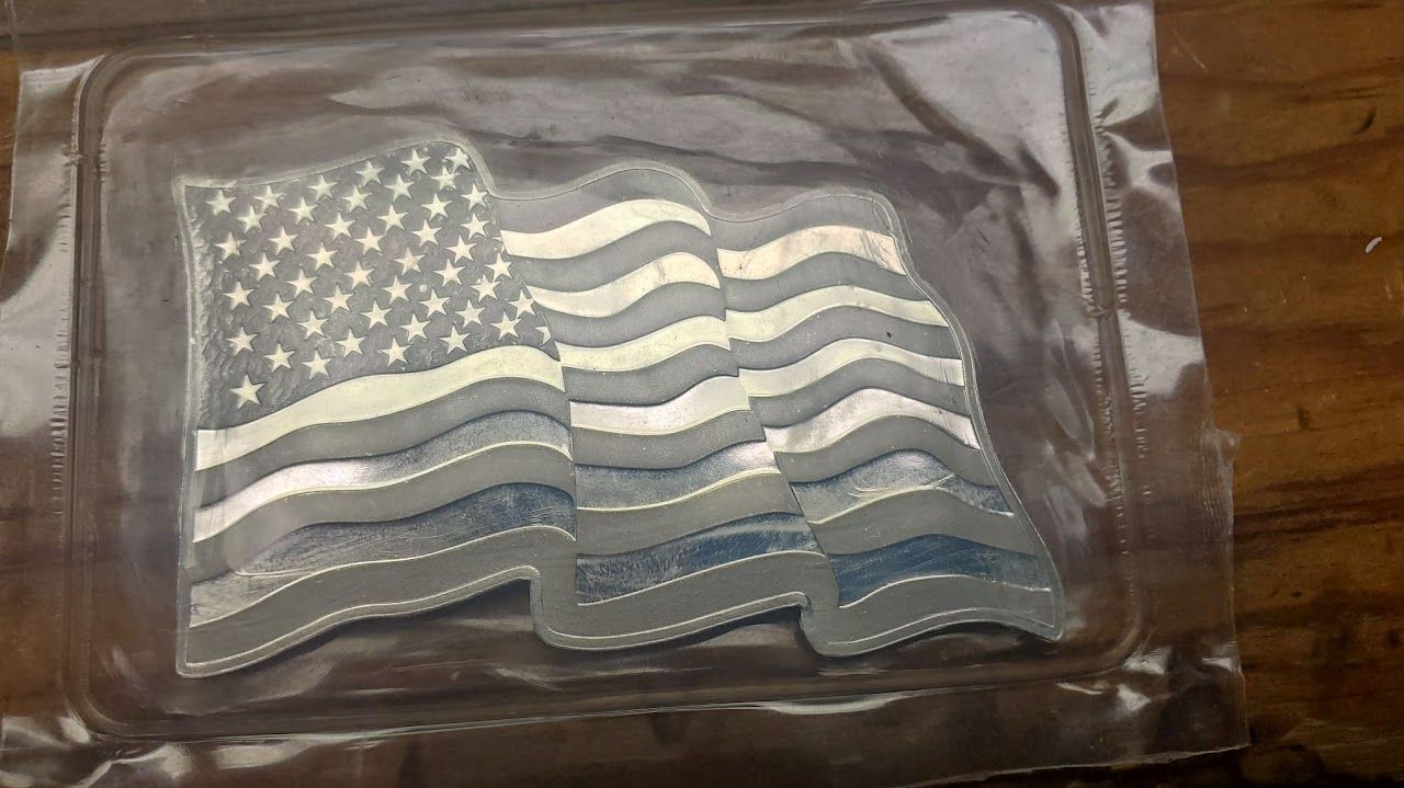 Silver American flag in a plastic sleeve.