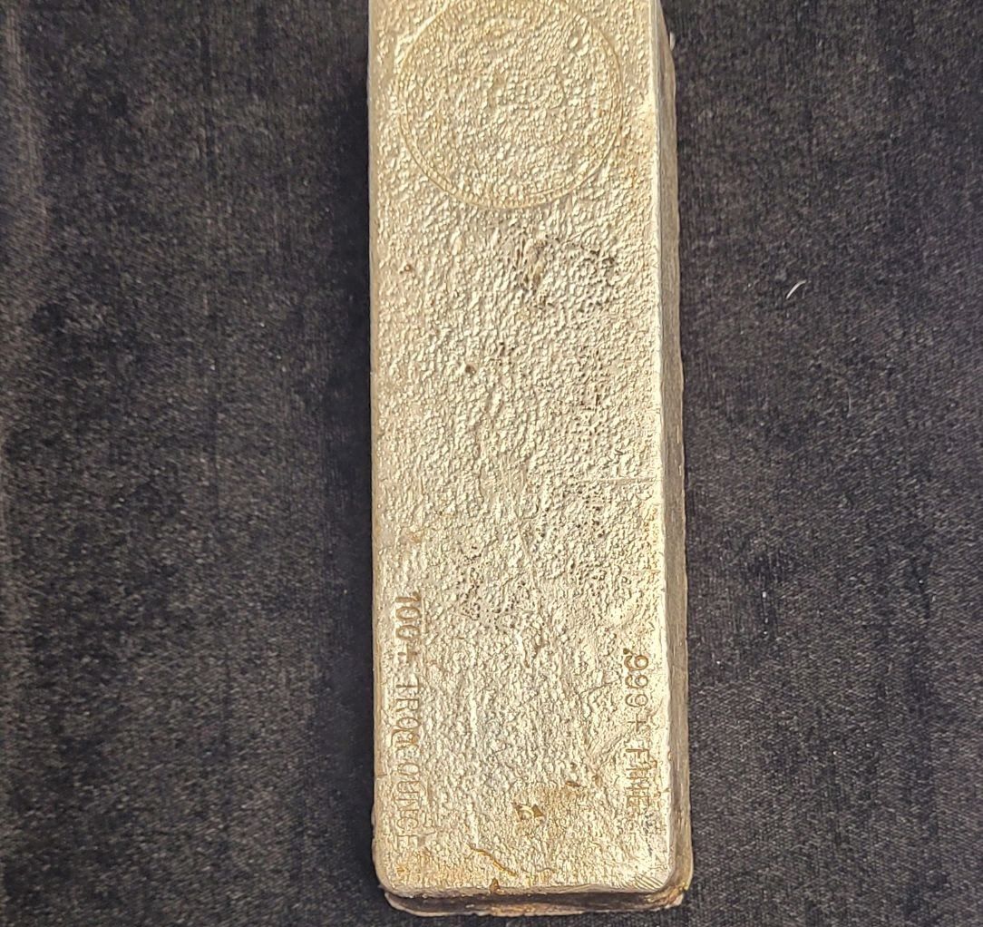 Silver bullion bar on a dark background.