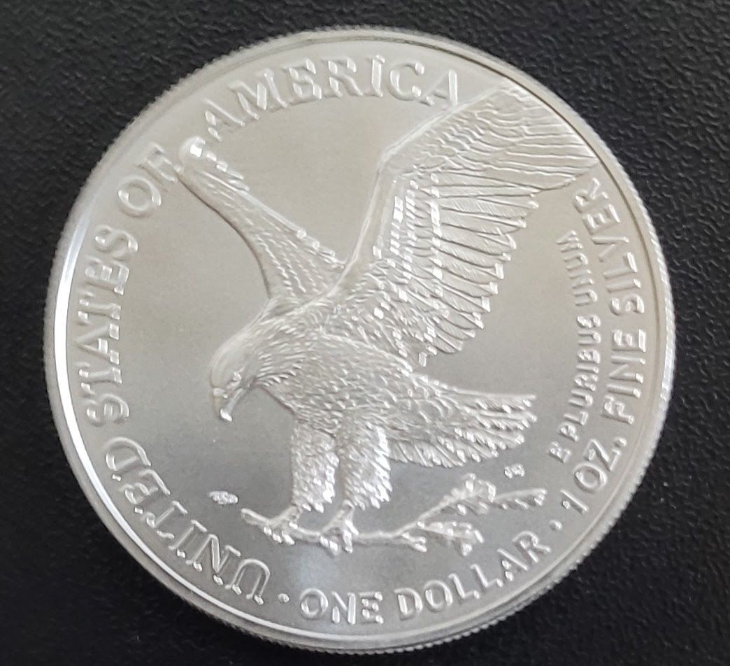 Silver dollar coin with an eagle on the reverse side.