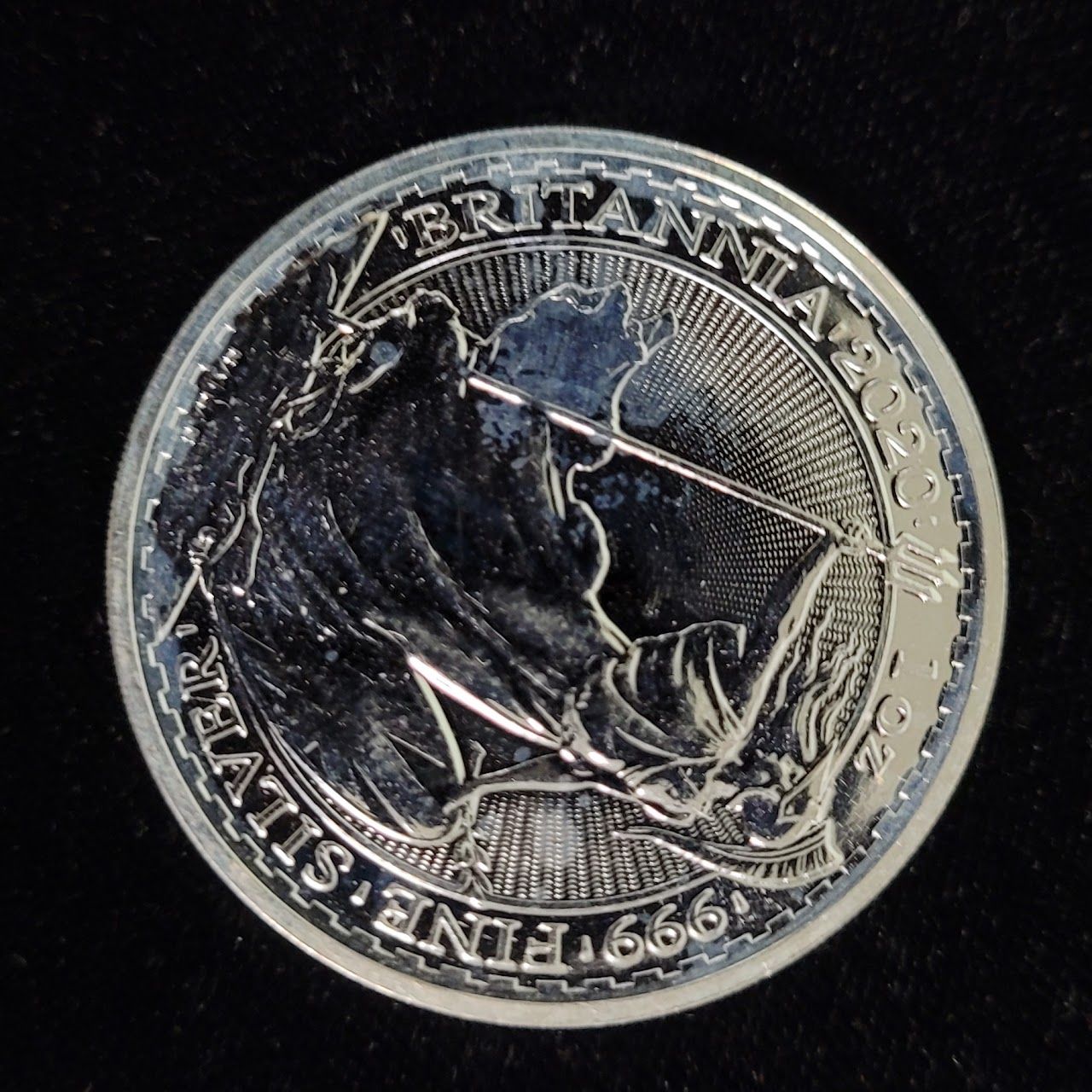 Silver coin with Britannia figure holding trident, inscription 