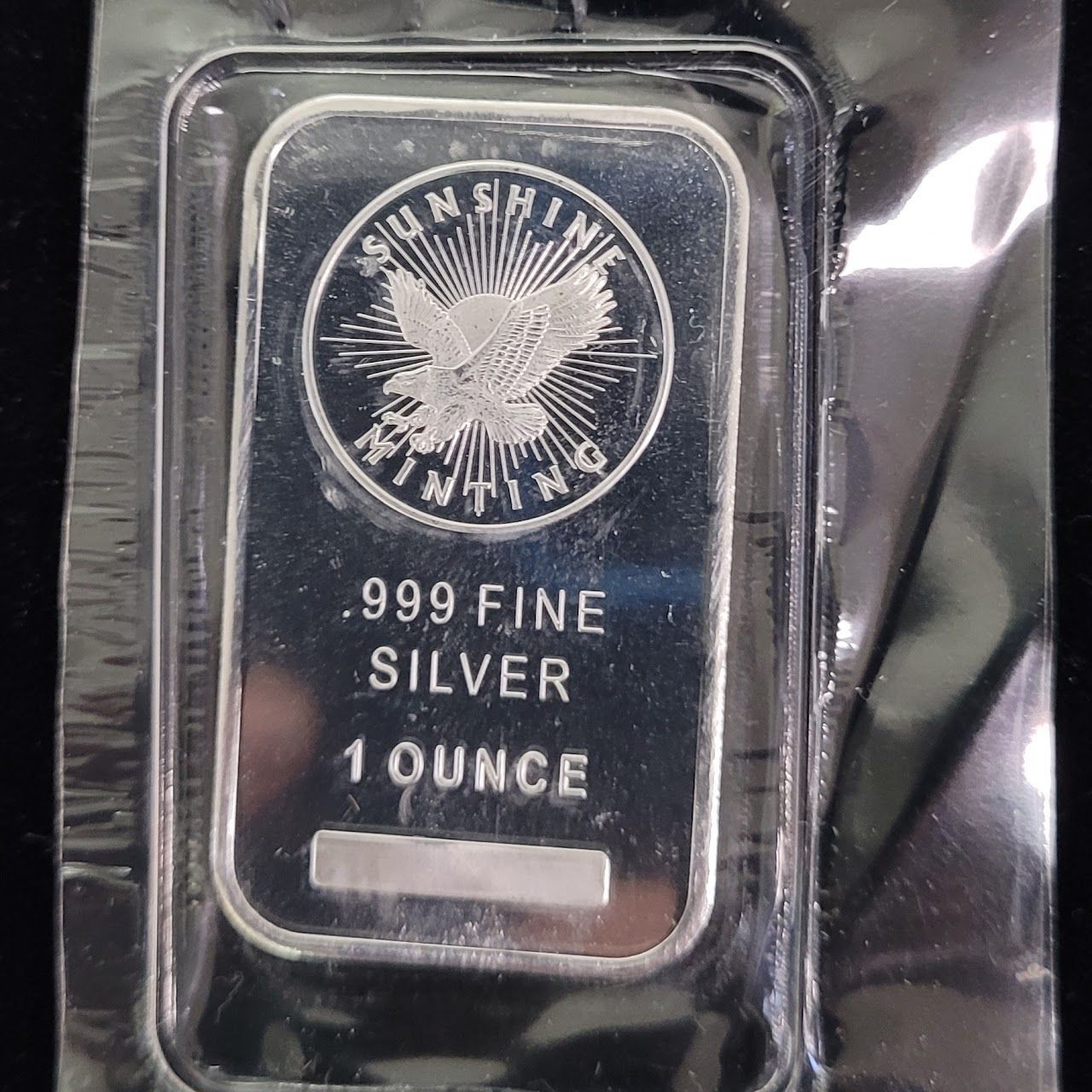 Silver 1 ounce bar in plastic packaging, stamped with 