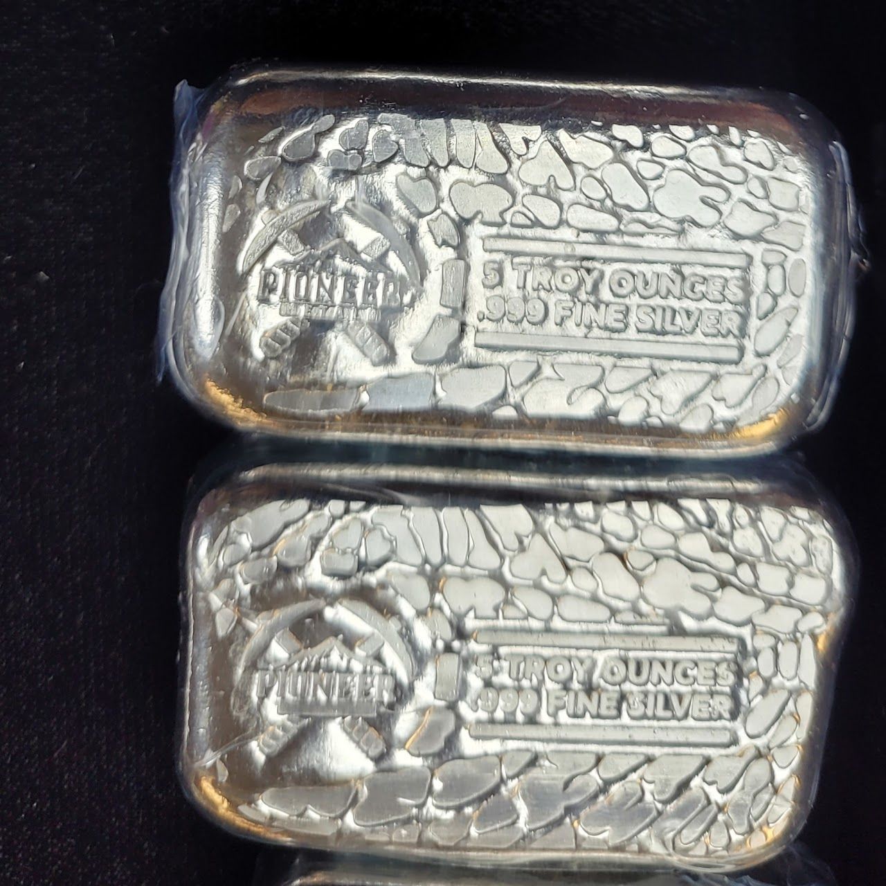 Two silver bullion bars, each labeled 
