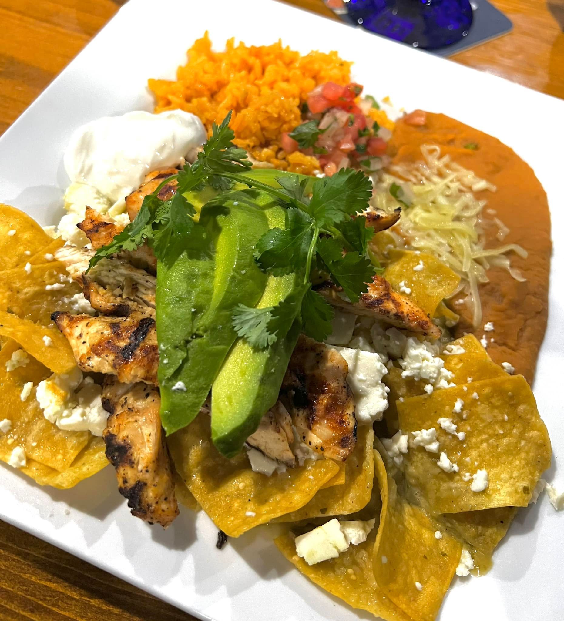 A close up of a plate of food with avocado and rice