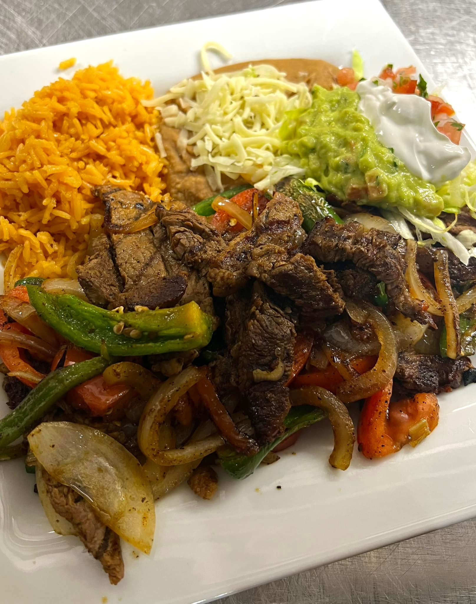 A white plate topped with a variety of mexican food.