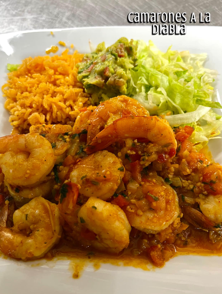 A white plate topped with shrimp guacamole and rice