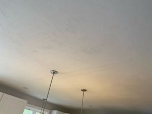 White ceiling with several dark spots; two pendant lights hang below.