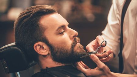A woman is getting her hair cut by a hairdresser in a salon.