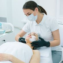 A woman with a mask on her face is getting a facial treatment.