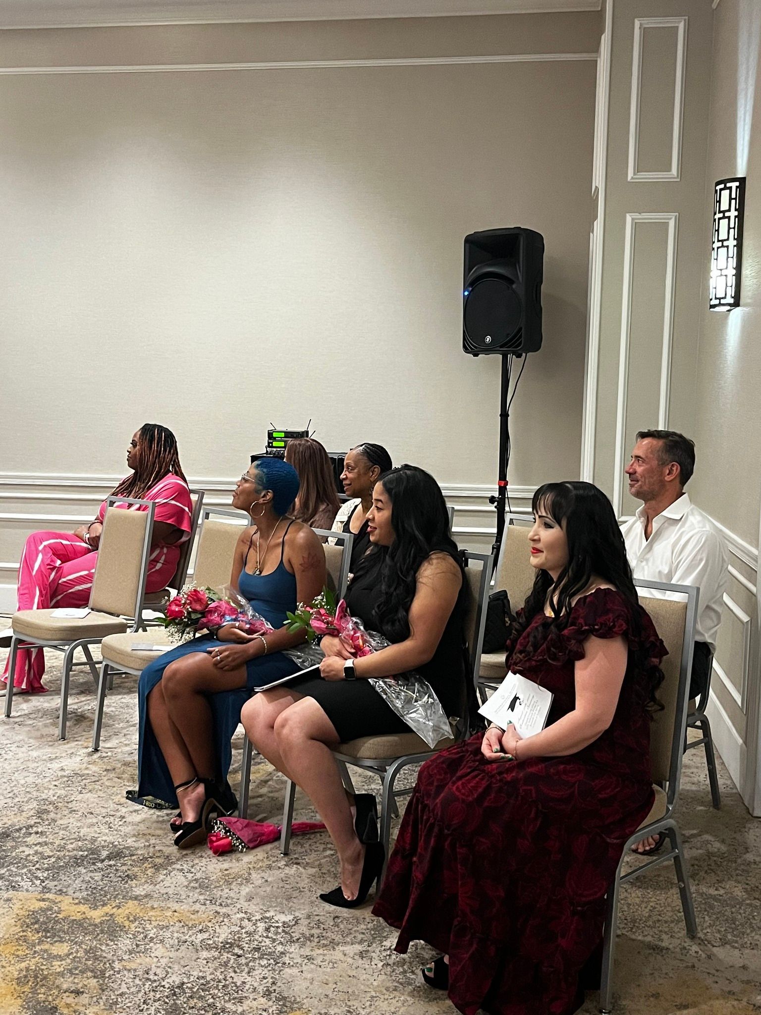 A group of women are sitting in chairs in a room.
