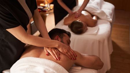 A man and a woman are getting a massage at a spa.