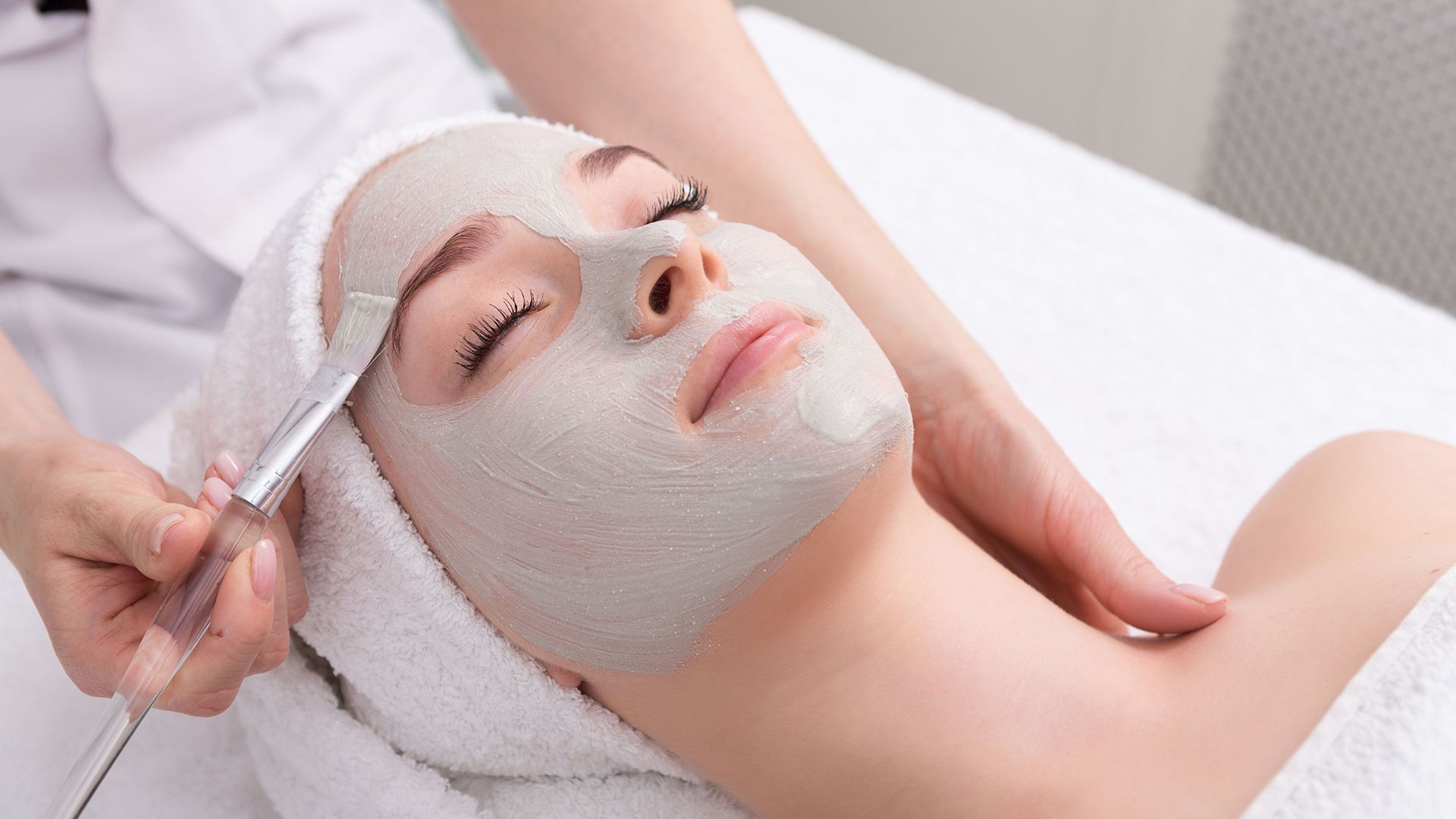 A woman is getting a facial treatment at a spa.