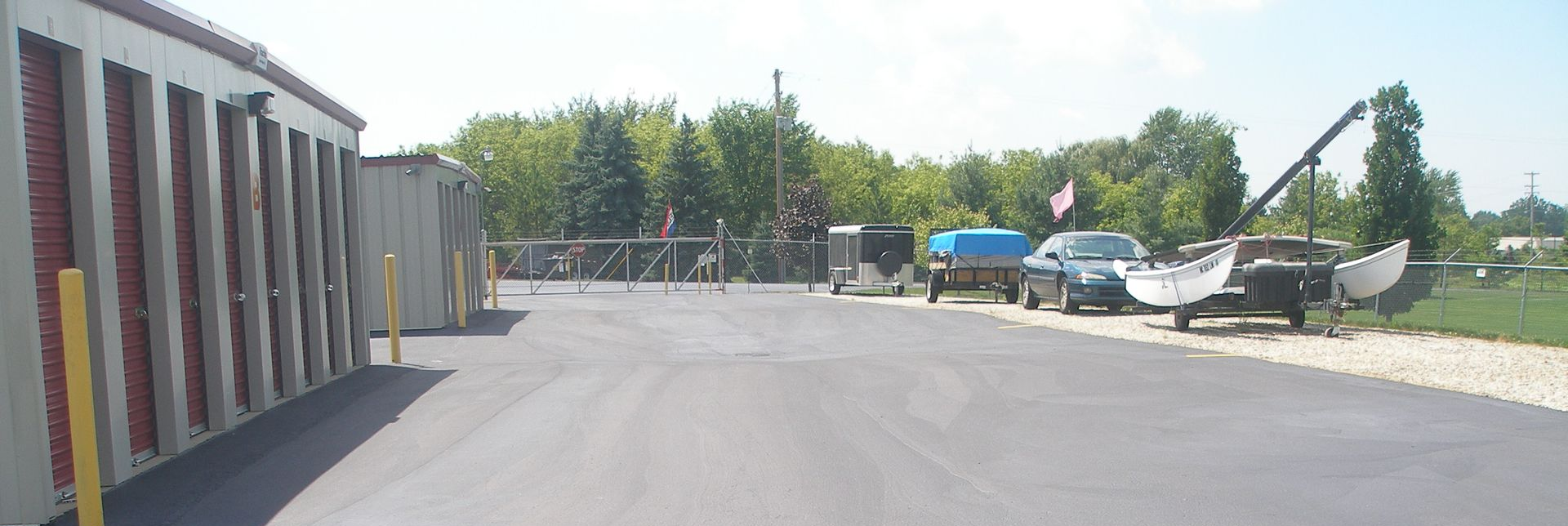 Storage units with a gated entrance and parked vehicles.