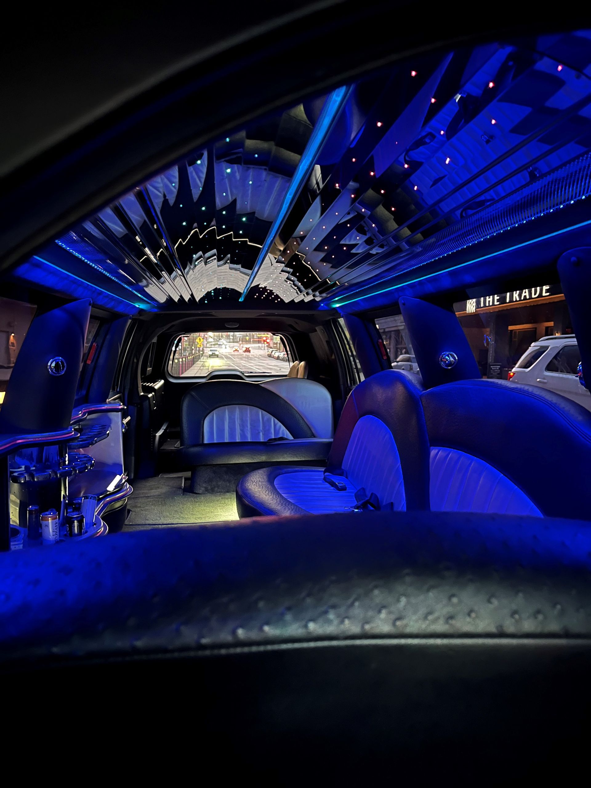 The inside of a limousine with blue lights on the ceiling