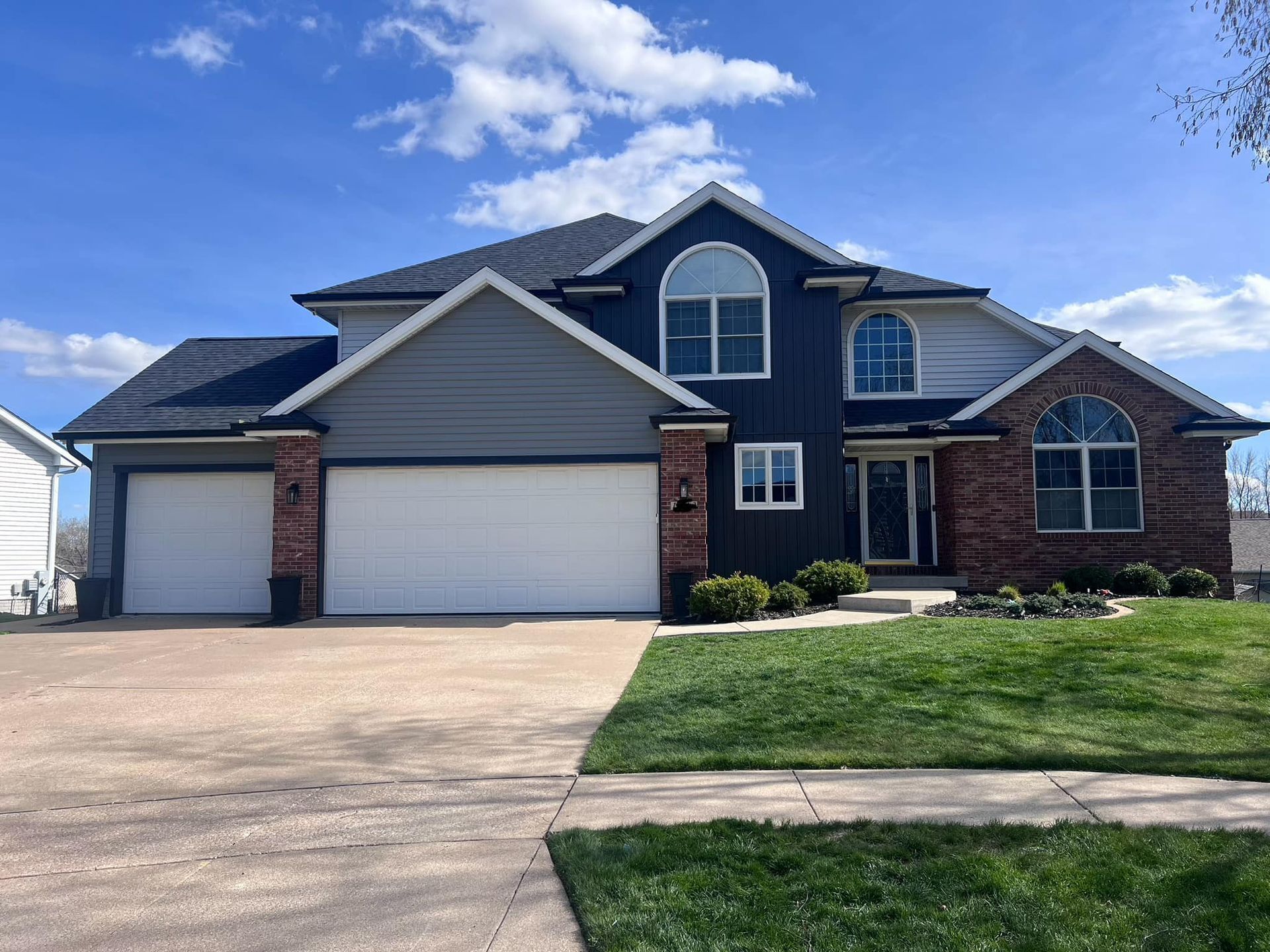 A large house with a lot of windows and a large driveway.