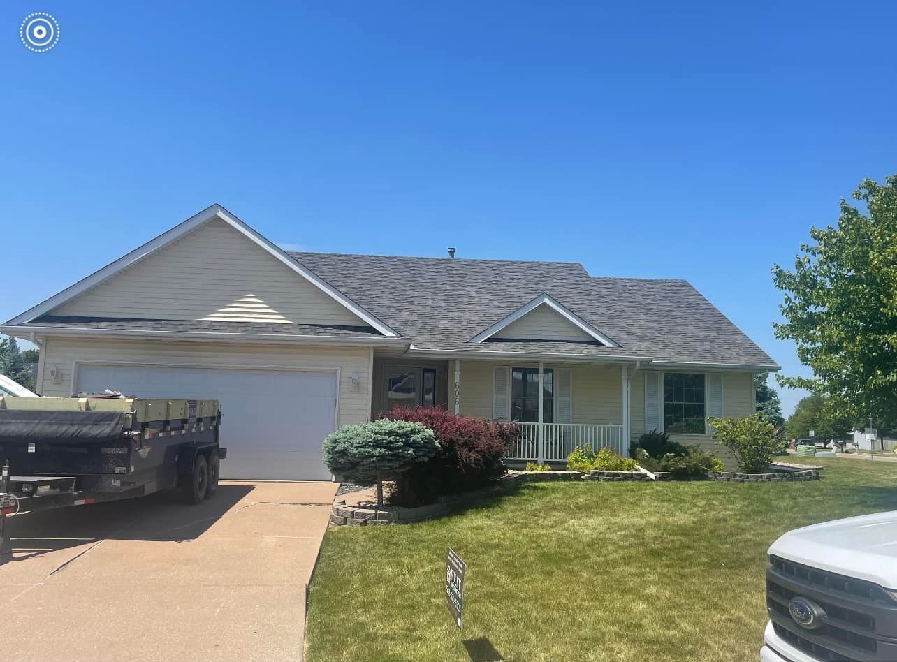 A white house with a truck parked in front of it.
