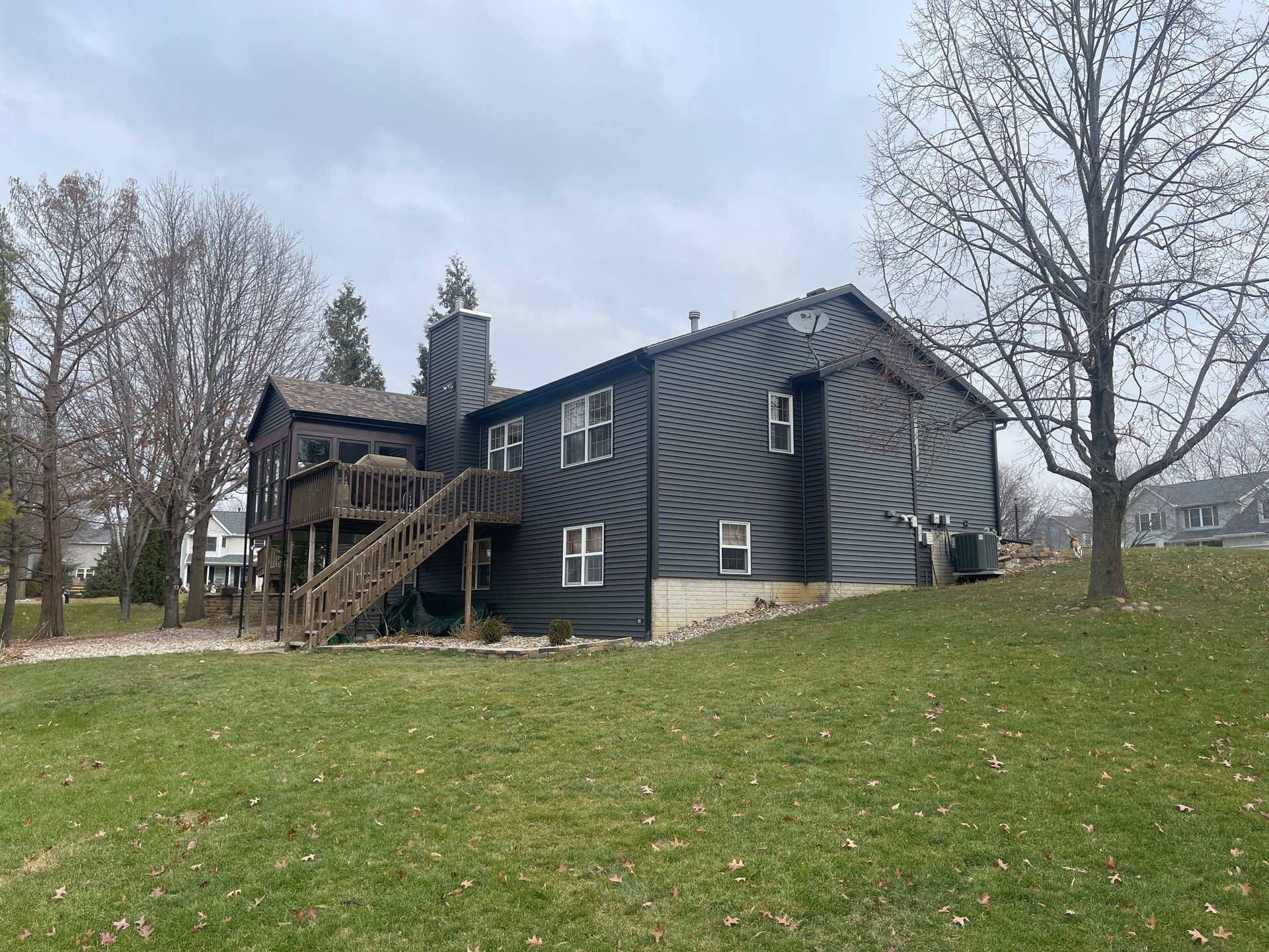 A large house is sitting on top of a lush green hill.