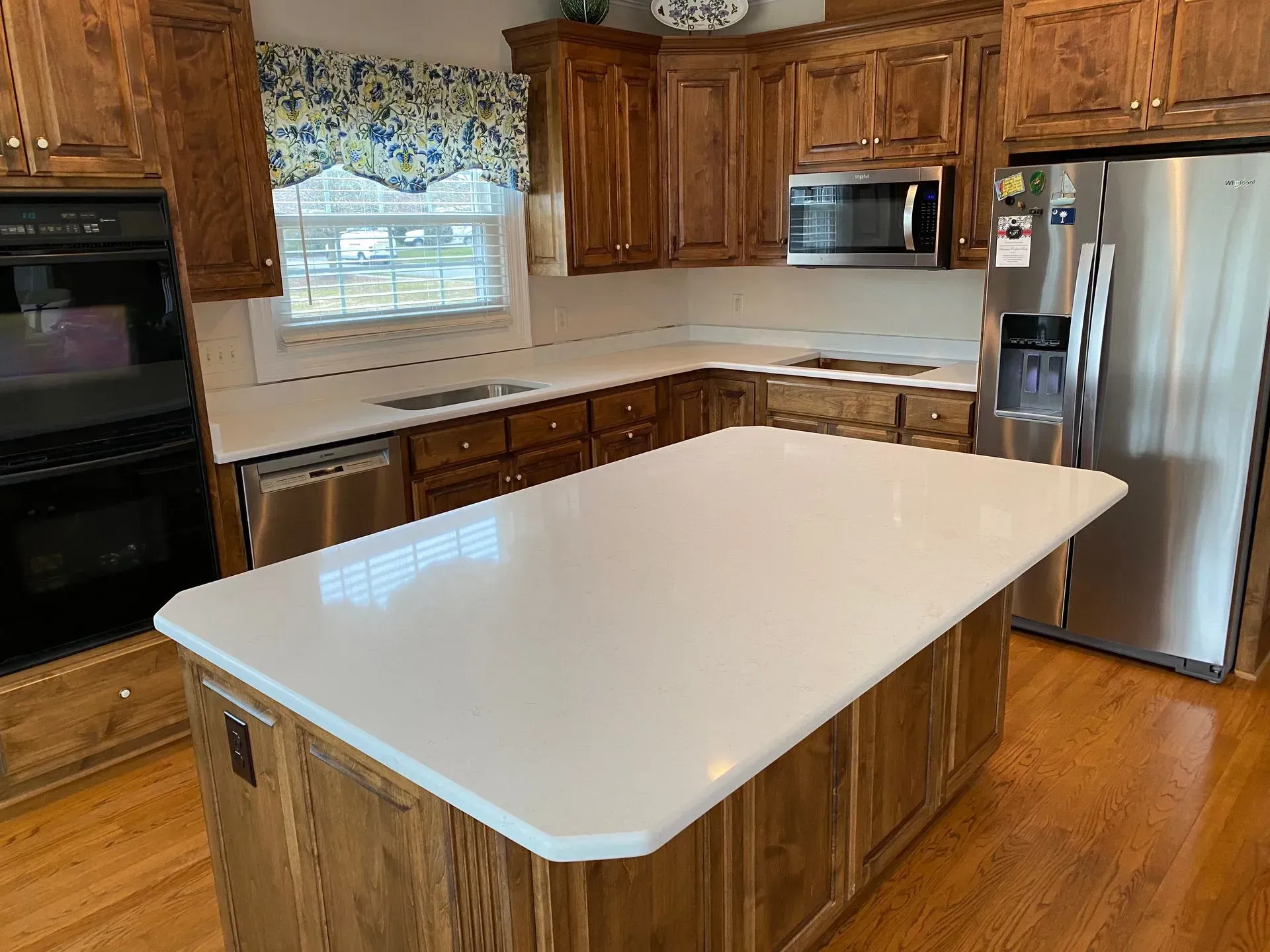 Exterior of a brick building with granite slabs in the foreground, under a partly cloudy sky.