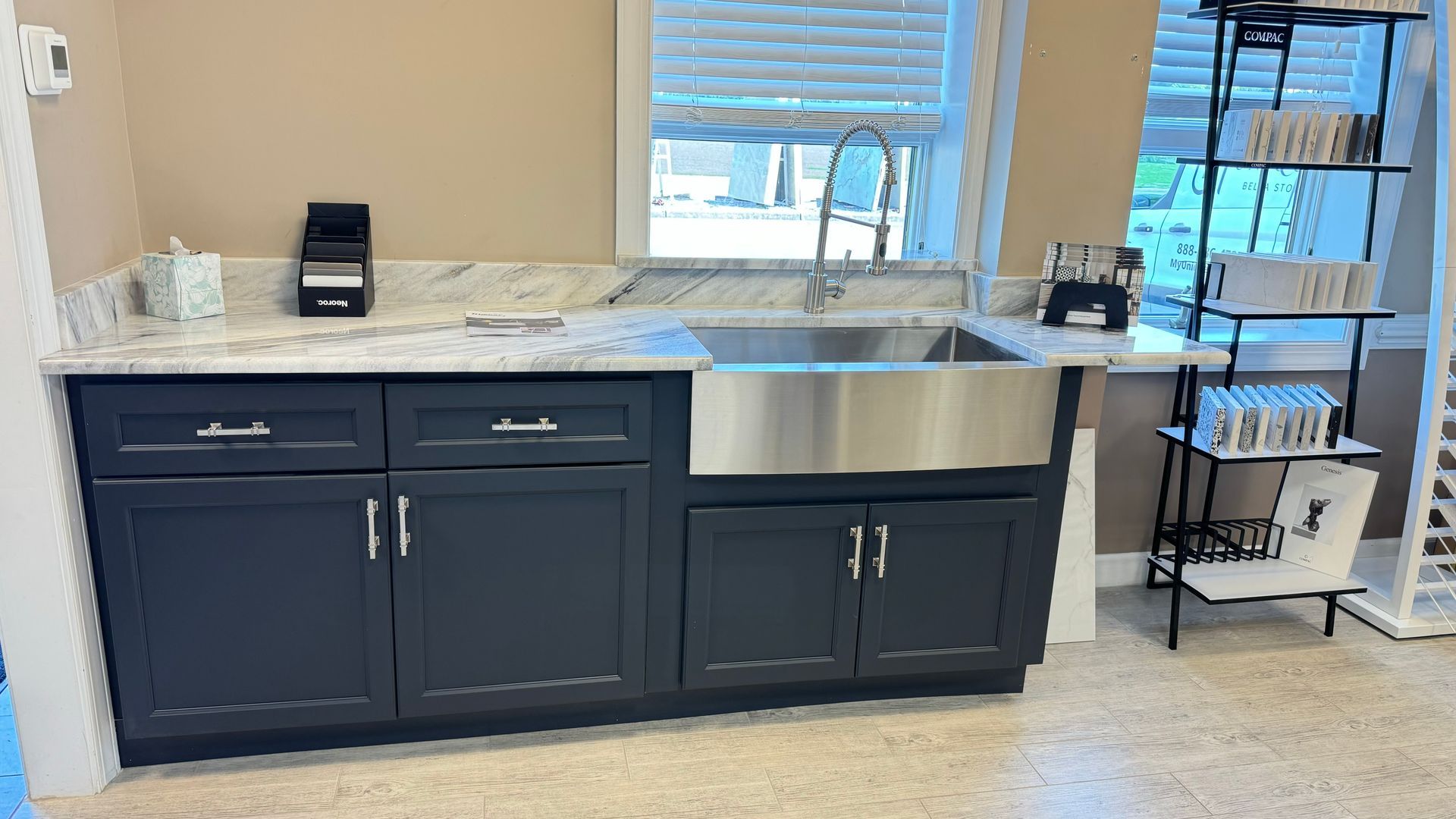 Navy blue cabinets with granite countertop, stainless steel sink. Window above sink.