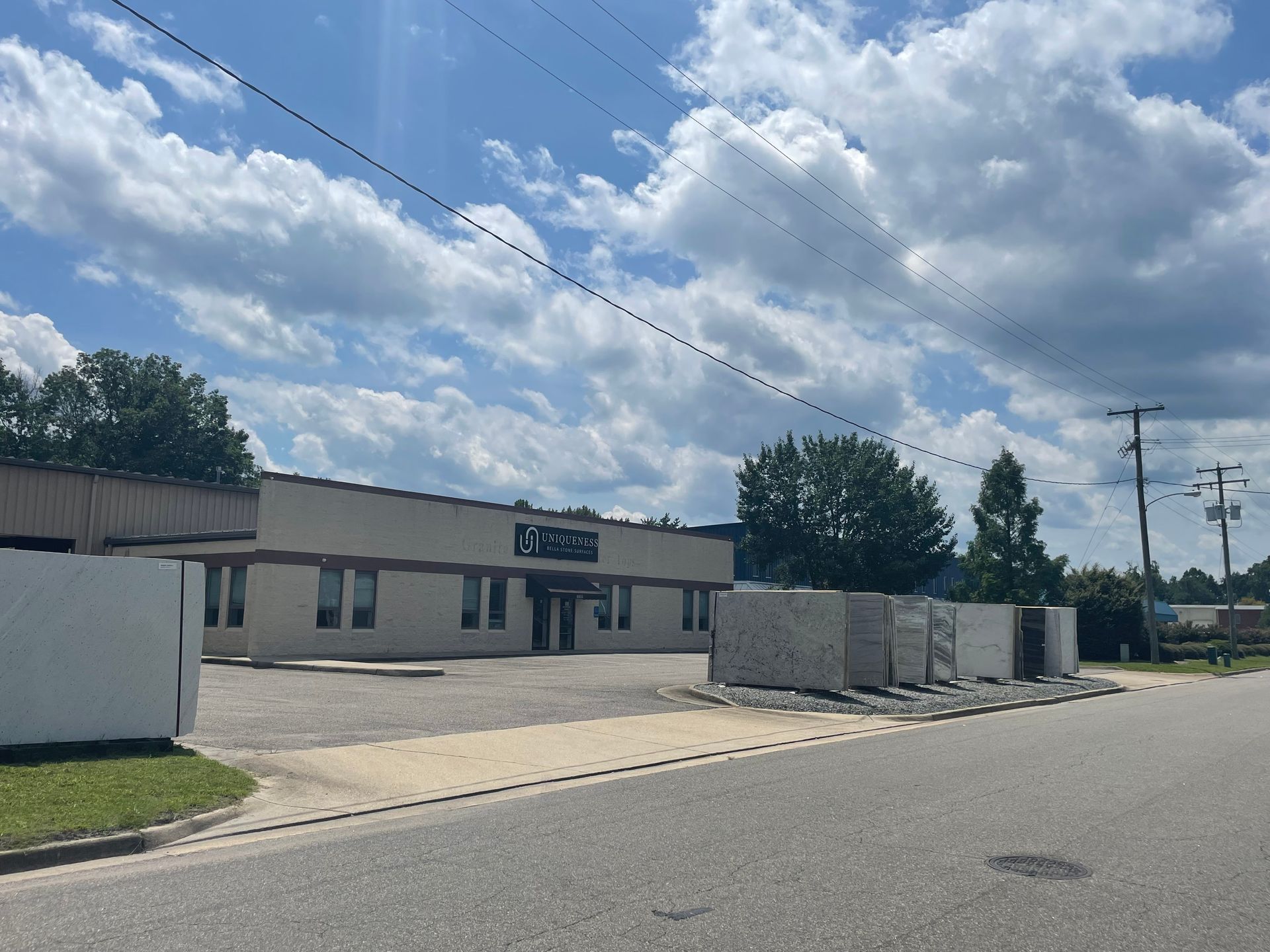 Building with a sign, overcast sky. Cement blocks and electrical poles are in the foreground.