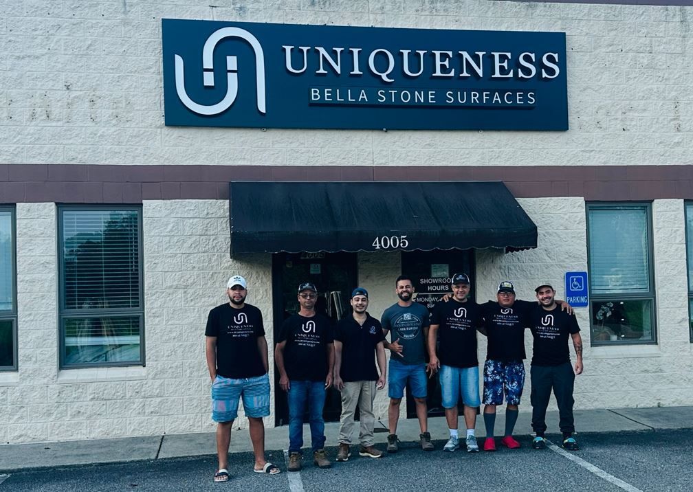 Group of seven people standing in front of a business called 