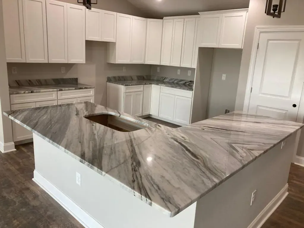 White kitchen with gray marbled countertop and cabinets.