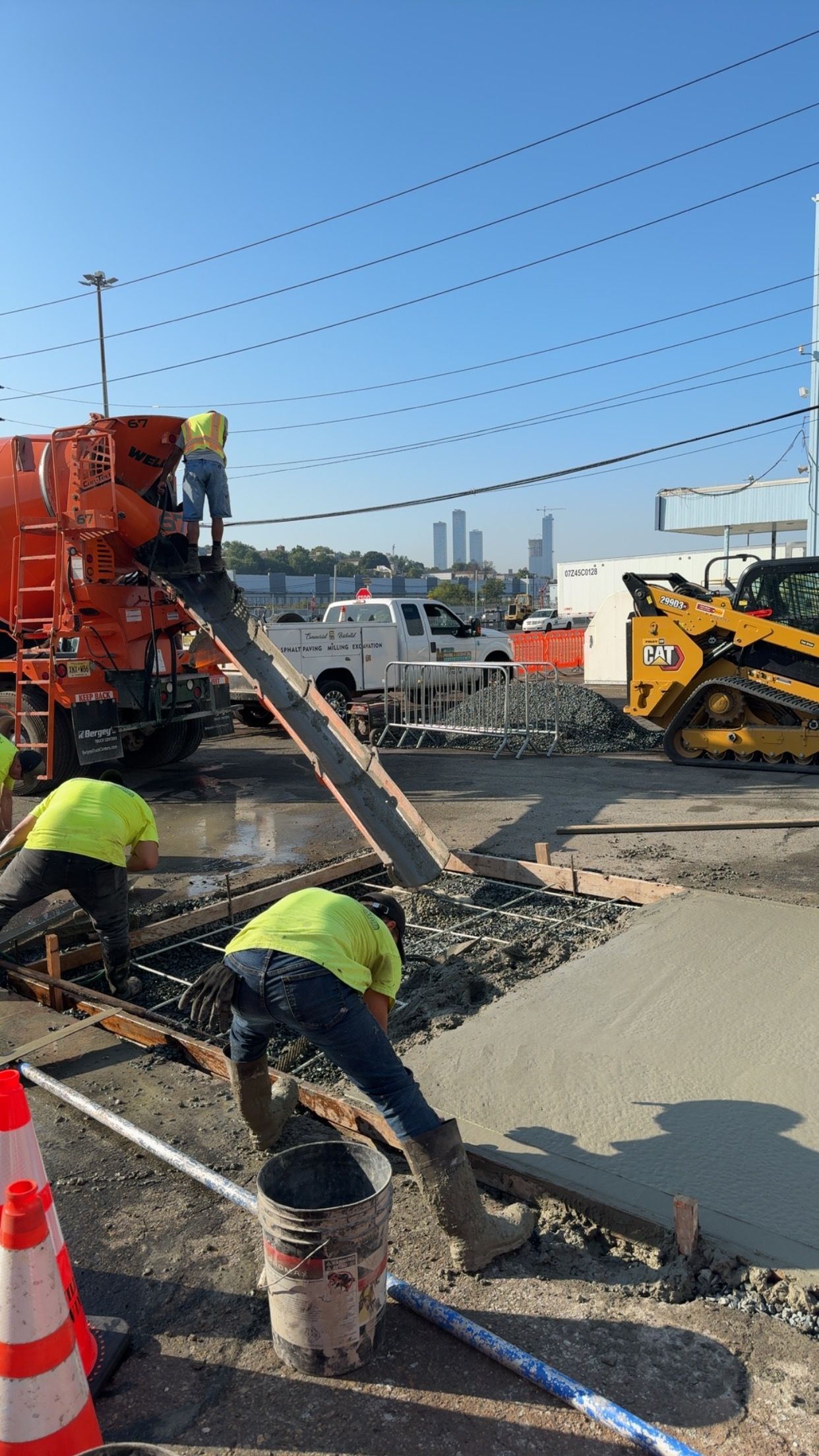 A group of construction workers are working on a sidewalk.
