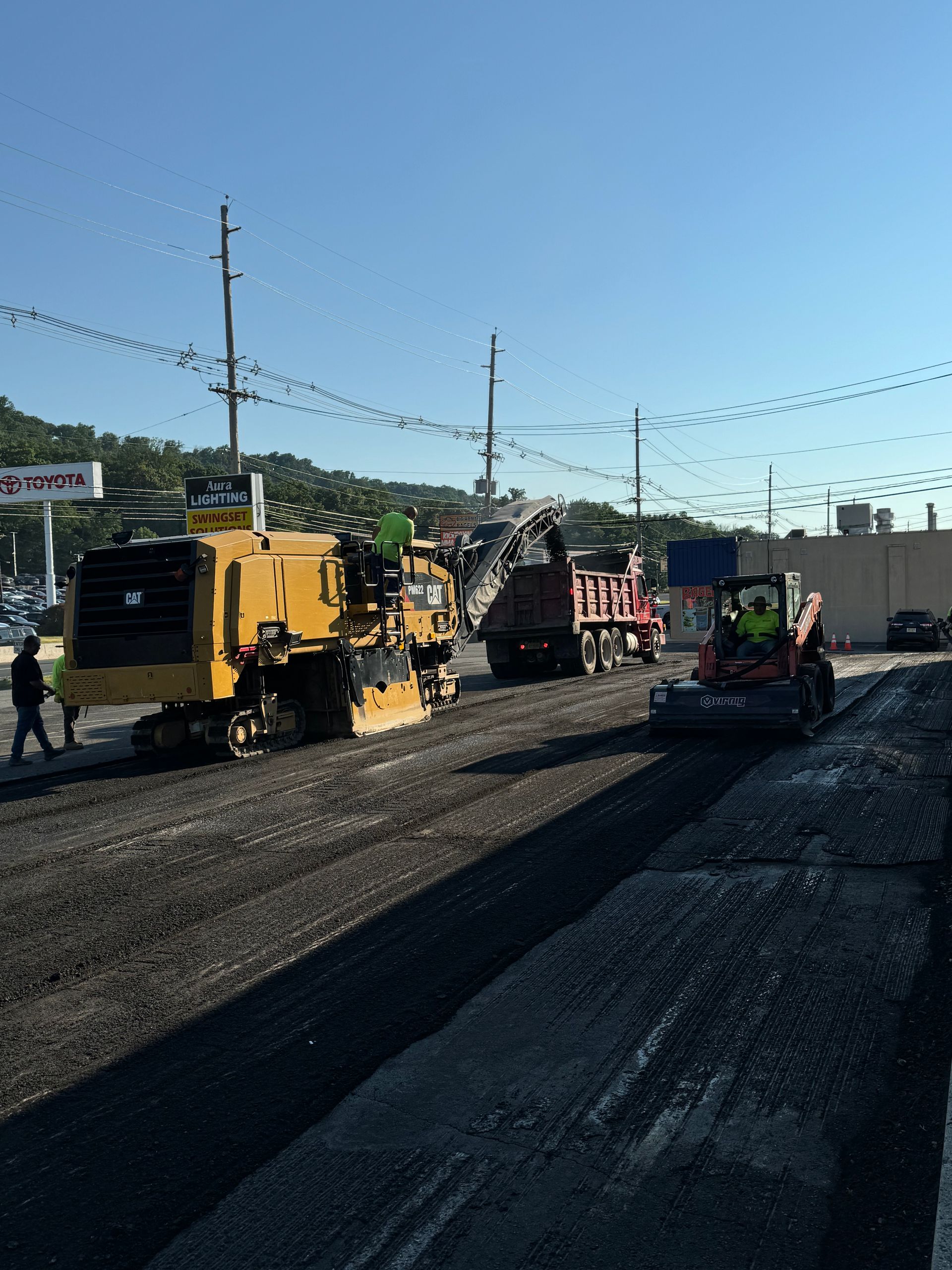 A group of construction vehicles are working on a road.